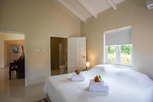 - une chambre dotée d'un lit blanc avec deux fleurs dans l'établissement Attractive villa in resort, à Willemstad