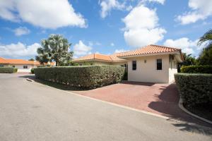 une maison dans une rue bordée de buissons et d'arbres dans l'établissement Attractive villa in resort, à Willemstad