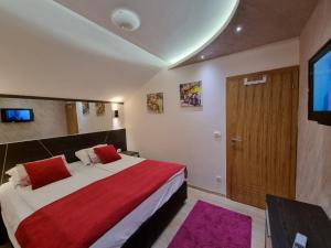 a bedroom with a bed with a red blanket and a door at Apartman Prestige Jahorina in Jahorina