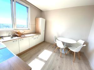a kitchen with a table and chairs and a sink at The Penthouse Rebreanu Towers in Timişoara