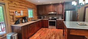 a kitchen with wooden cabinets and a counter top at Tobermory Peaceful Private Entire Cottage Log Home Spacious Fully Equipped in Miller Lake