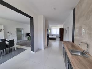 a large white kitchen with a sink and a living room at Schönes modernes Loft in Essen - Südviertel in Essen