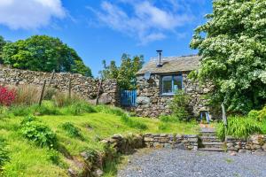 a stone cottage with a stone wall and a stone path at Finest Retreats - Woodend - The Bothy in Ulpha