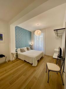sypialnia z łóżkiem, krzesłem i telewizorem w obiekcie B&B Il Gabbiano w mieście Orbetello +21 zdjęć