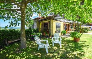 zwei Stühle und ein Baum vor einem Haus in der Unterkunft Stunning Home In Valentano With Kitchen in Valentano