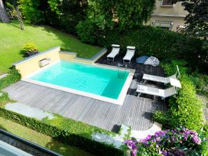 einen Blick über einen Pool mit Stühlen und Blumen in der Unterkunft Depandance Agave in Gardone Riviera
