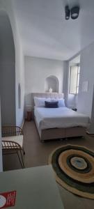 a bedroom with a large bed and a chair at Guru accommodations in Mikonos