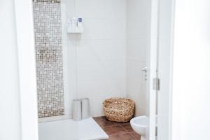 La salle de bains blanche est pourvue d'une douche et de toilettes. dans l'établissement Rest House - Vila do Conde, à Vila do Conde