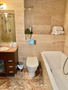 a bathroom with a toilet and a tub and a sink at Ocean Village Lovely 2 bedroom apartment in Gibraltar