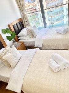 Habitación de hotel con 2 camas y ventana en Ocean Village Lovely 2 bedroom apartment en Gibraltar