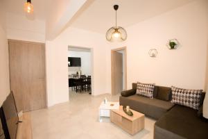 a living room with a couch and a table at Sea Gem Apartment 1 in Neoi Epivates