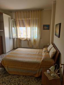 sypialnia z dużym łóżkiem i oknem w obiekcie Casa Anna w Agropoli