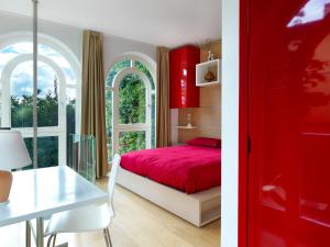 a bedroom with a red bed and a table at Depandance Agave in Gardone Riviera