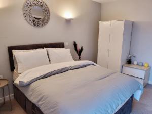 une chambre avec un lit avec un miroir au mur dans l'établissement Luxury City Apartment in JQuarter Birmingham, à Birmingham