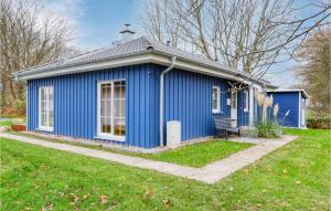 a blue house with a bench in a yard at Ferienhaus 28 Altefhr in Altefähr