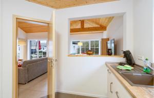 a kitchen with a sink and a living room at Ferienhaus 28 Altefähr in Altefähr +23 photos