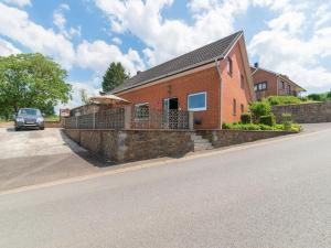 een stenen huis met een stenen muur naast een straat bij Charming holiday home in Marche en Famenne with garden in Marche-en-Famenne