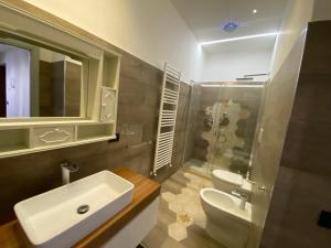 um banheiro com uma pia, um vaso sanitário e um espelho em Centro & Mare II em Savona mais 12 fotografias