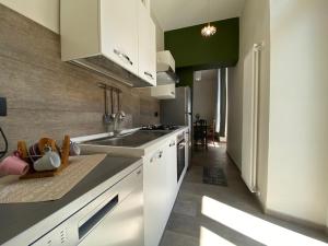 uma cozinha com armários brancos e uma pia em Centro & Mare II em Savona