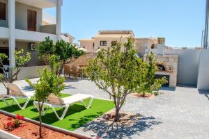 un patio avec des chaises et des arbres dans un bâtiment dans l'établissement MD Residence near the beach w BBQ and private parking, à Chersónissos