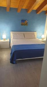 1 dormitorio con 1 cama grande y pared azul en Casa Nettuno in Villa Marisa, en Borgo Bonsignore