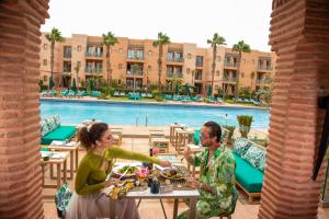 un homme et une femme assis à une table avec de la nourriture dans l'établissement Jaal Riad Resort - Adults Only, à Marrakech