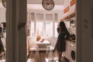 a woman standing in a kitchen next to a table at Chez Pepito & Zaza hypercentre rooftop garage in Nîmes