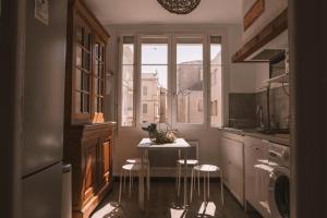 cocina con mesa, sillas y ventana en Chez Pepito & Zaza hypercentre rooftop garage, en Nimes