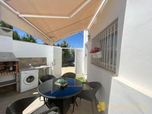 a patio with a table and chairs and a kitchen at Casa Nina in Vejer de la Frontera
