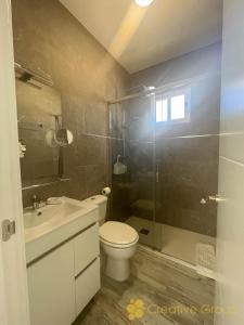 a bathroom with a toilet and a sink and a shower at Casa Nina in Vejer de la Frontera
