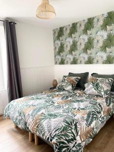 1 dormitorio con 1 cama con estampado tropical en la pared en Les Jardins du Château, en Châteauroux