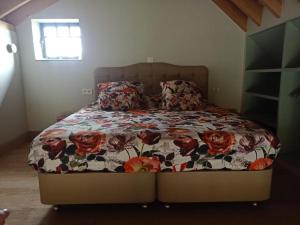 a bed with a floral comforter in a bedroom at Mademoiselle Nineth met sauna in De Panne