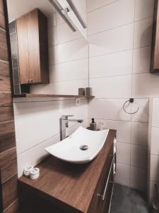a bathroom with a white sink on a wooden counter at Coquette studio in Oradea +20 photos