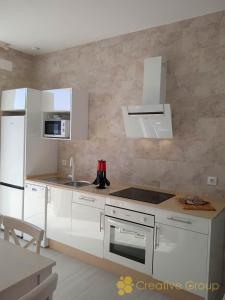 a kitchen with white cabinets and a stove top oven at Casa Alma in Vejer de la Frontera