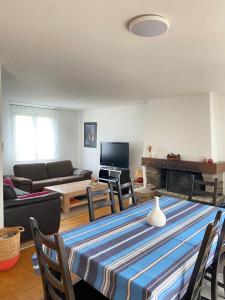 a living room with a table with a couch and a fireplace at Le coteau in Le Palais