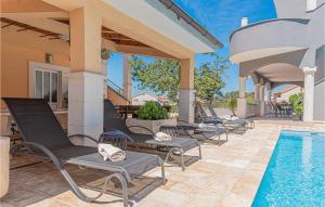 a row of patio chairs next to a swimming pool at Beautiful Home In Brodarica With Wifi in Brodarica