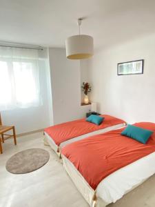 a bedroom with two beds with red sheets and blue pillows at Le coteau in Le Palais