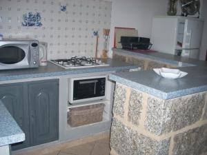 una cucina con fornelli e microonde di Demeure traditionnelle en pierre avec piscine a Sartène