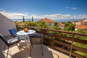 a patio with a table and chairs on a balcony at Apartments Filosevic by El-Pi Tours in Njivice