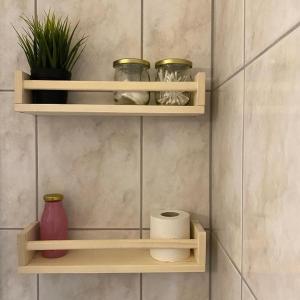 a wall with wooden shelves with vases and plants at Altes Stadtgut am Bauhaus Museum in Weimar