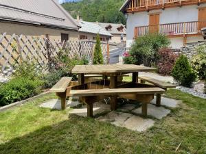a picnic table in the grass in a yard at Le Gabion, luxueux appartement avec 10 couchages et sauna, Serre chevalier Vallée in Saint-Chaffrey