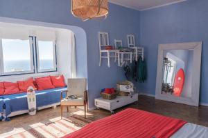 Chill in Ericeira Surf House في إيريسييرا: غرفة زرقاء مع سرير ومرآة