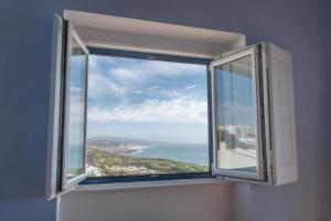 une fenêtre ouverte avec vue sur l'océan dans l'établissement Chill in Ericeira Surf House, à Ericeira
