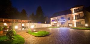 a large building with lights in a courtyard at night at Levendula Apartmanház in Sárvár