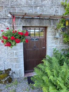 uma porta de madeira com um ramo de flores vermelhas em Maison de Campagne em Sarroux