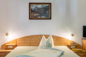 1 dormitorio con 1 cama con una foto en la pared en Sallrain Hof Monolokal 4, en Collalbo
