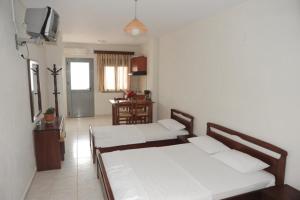 a living room with two beds and a table at Platis-Gialos apartments in Loutsa
