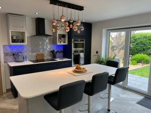 Stylish Modern Home with Parking Enclosed Garden في هوليهيد: مطبخ مع طاولة عليها صحن من الفواكه