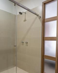 um chuveiro com uma porta de vidro ao lado de uma janela em Primavera Plus em Villavicencio