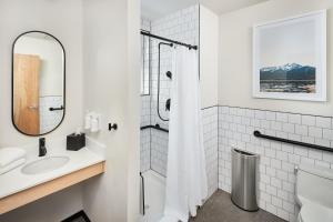 a white bathroom with a sink and a shower at Kinship Landing in Colorado Springs